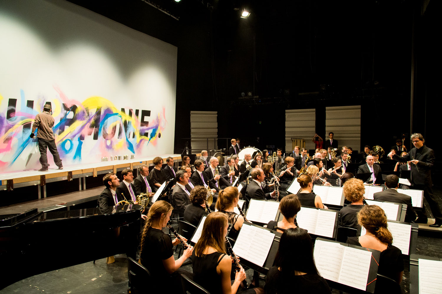 alex kanos painting during a concert of harmonic orchestra