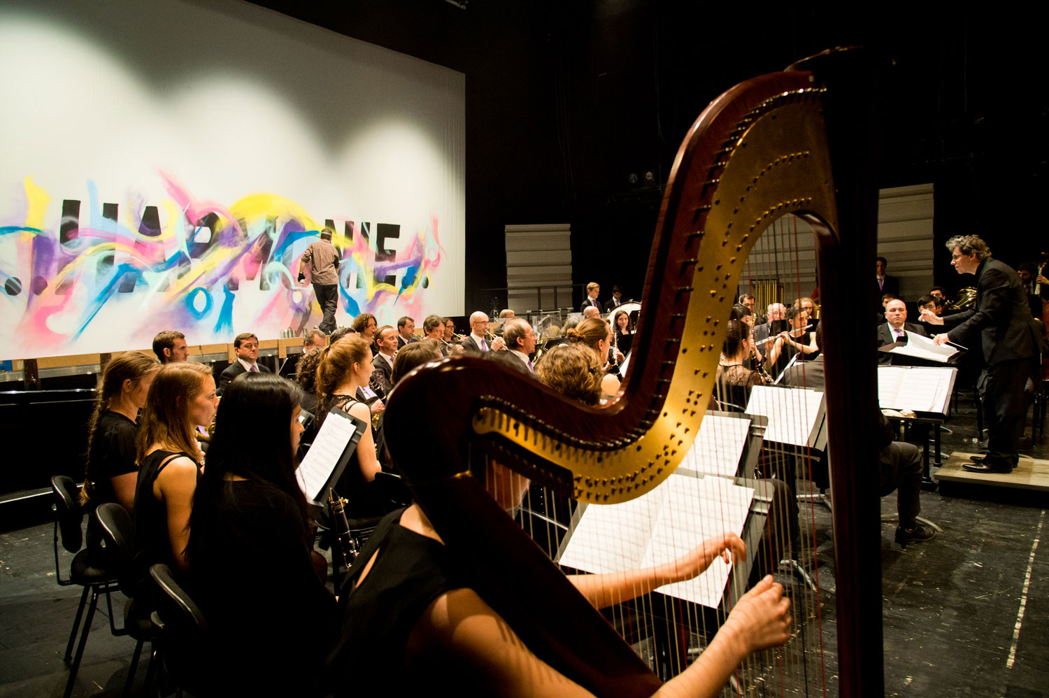 alex kanos painting during a concert of harmonic orchestra