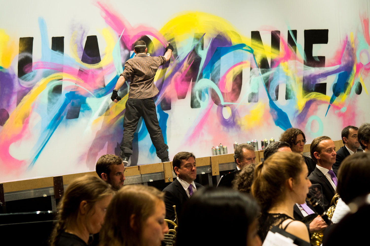 alex kanos painting during a concert of harmonic orchestra