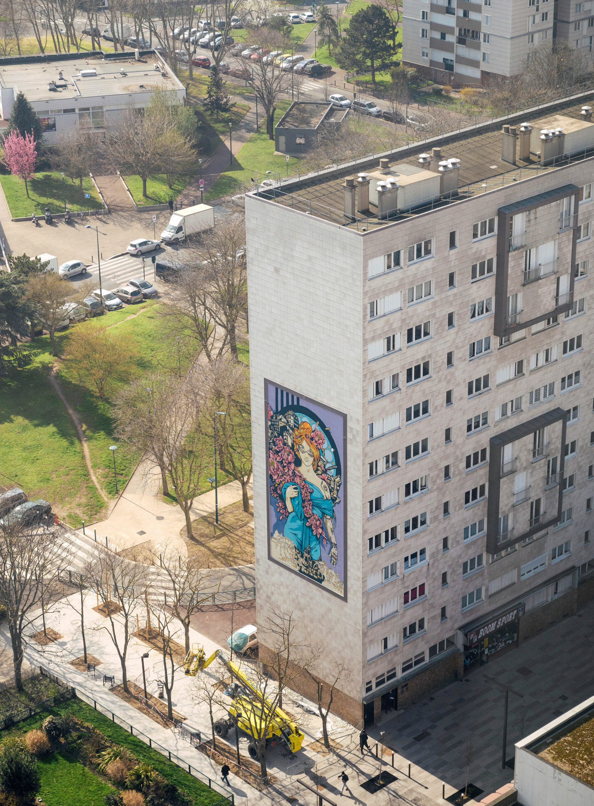 a huge mural with a feminine character tribute to mucha with cyberpunk elements shot from above