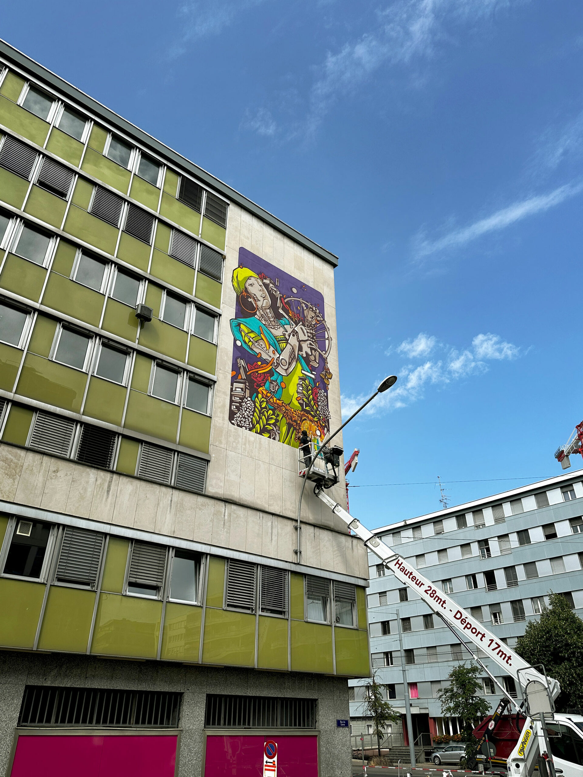 Alex Kanos is painting a mural in Geneva